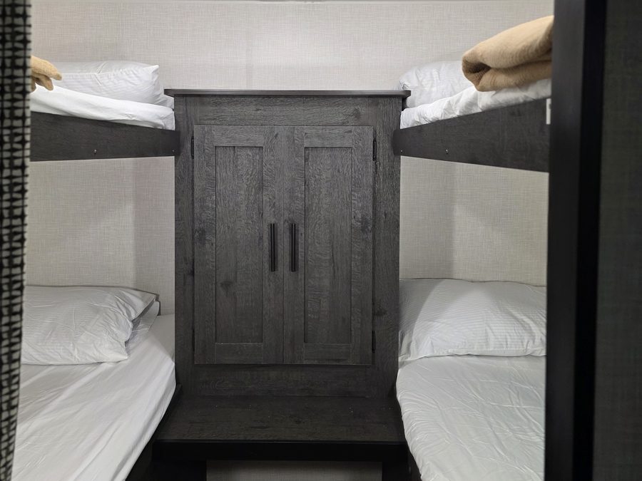 Two sets of bunk beds with a cabinet between them in the bunkhouse RV rental